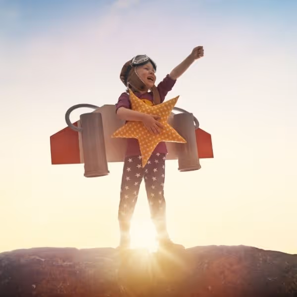 Criança fantasiada de astronauta, ilustrando a vitalidade que o tratamento reumatológico pediátrico busca preservar.
